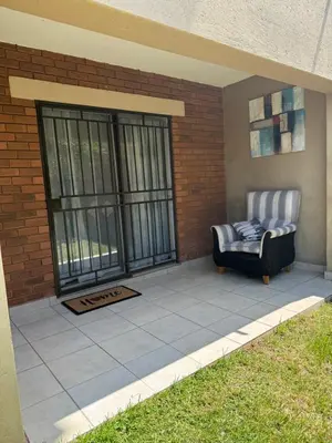 a patio with a chair and a window at Awesome family home in Midrand