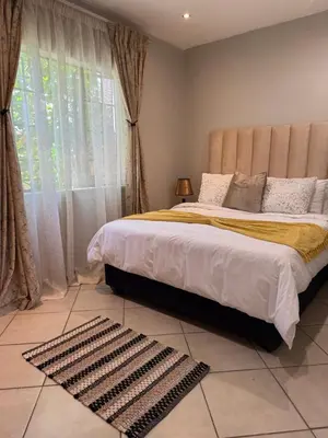 a bedroom with a large bed and a window at Awesome family home in Midrand
