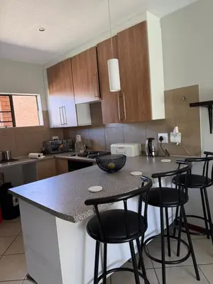 a kitchen with a counter and bar stools at Awesome family home in Midrand