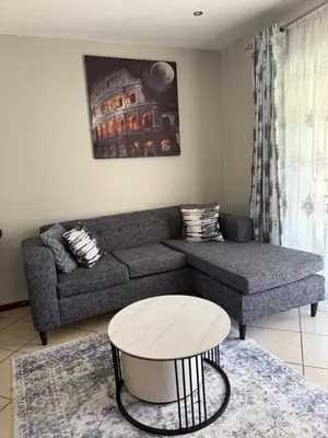 a living room with a couch and a table at Awesome family home in Midrand