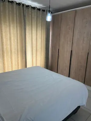 a bedroom with a white bed and a curtain at Lux Easy Stay in Pretoria