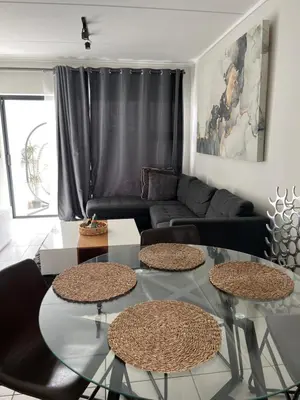 a living room with two tables and a couch at Lux Easy Stay in Pretoria