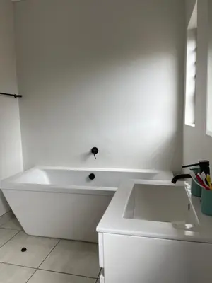 a white bathroom with a tub and a sink at Lux Easy Stay in Pretoria