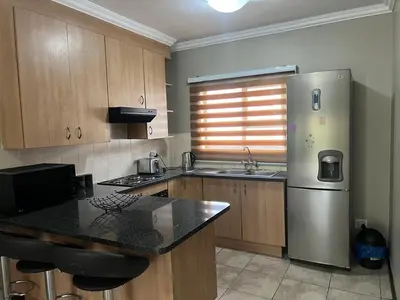 a kitchen with a stainless steel refrigerator and a sink at Spacious Apartment Near Gautrain, Gallagher & MOA in Midrand