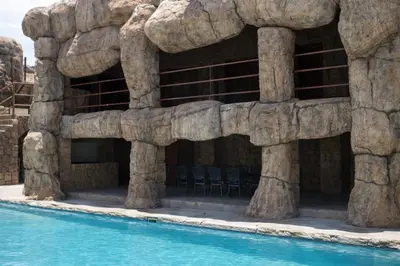 a rock wall next to a swimming pool at Ndou The Rocks Lodge in Hammanskraal Station