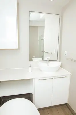 a white bathroom with a sink and a mirror at Regency Apartment Hotel Unit 311 in Pretoria