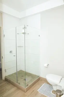 a glass shower in a bathroom with a toilet at Regency Apartment Hotel Unit 311 in Pretoria