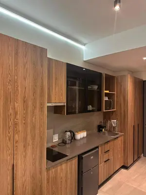 a kitchen with wooden cabinets and a counter top at Modern Studio Apartment in The Capital Trilogy in Pretoria