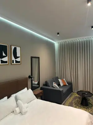a hotel room with a bed and a couch at Modern Studio Apartment in The Capital Trilogy in Pretoria