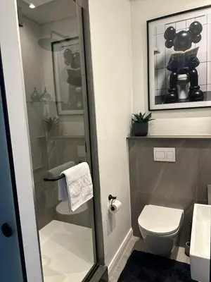 a bathroom with a toilet and a glass shower at Modern Studio Apartment in The Capital Trilogy in Pretoria