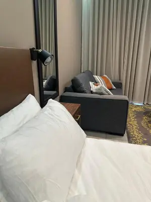 a bedroom with a bed and a couch and a mirror at Modern Studio Apartment in The Capital Trilogy in Pretoria