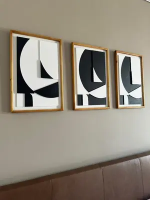 three framed pictures on a wall above a couch at Modern Studio Apartment in The Capital Trilogy in Pretoria