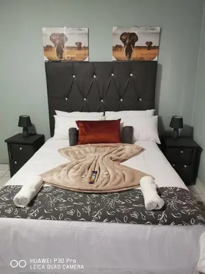 a large bed with a large wooden blanket on it at A home away from Home in Musina