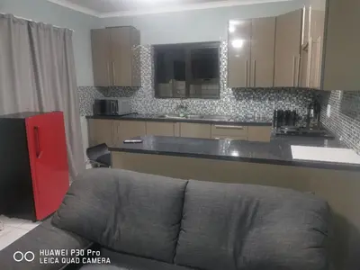 a kitchen with a couch in front of a counter at A home away from Home in Musina