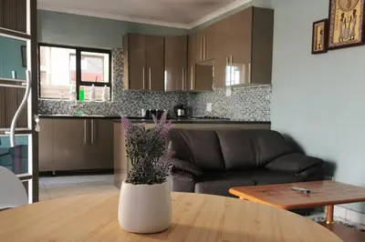 a vase with flowers on a table in a living room at A home away from Home in Musina