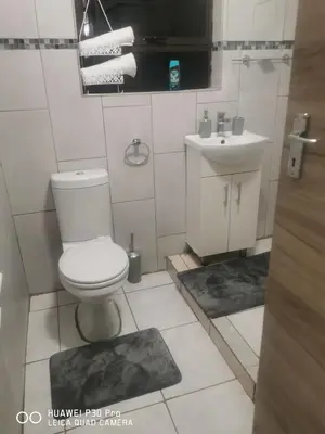 a bathroom with a toilet and a sink at A home away from Home in Musina