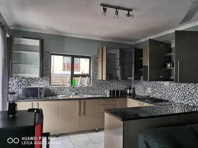 a kitchen with black and white tile on the walls at A home away from Home in Musina