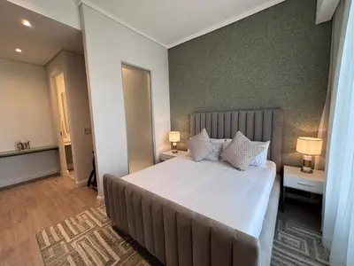 a bedroom with a large bed with white sheets and pillows at Signature Luxury Living Experience - The Trilogy Collection in Pretoria