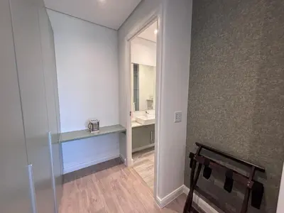 a bathroom with a sink and a mirror and a bench at Signature Luxury Living Experience - The Trilogy Collection in Pretoria