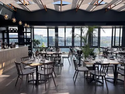 a restaurant with tables and chairs and windows at Signature Luxury Living Experience - The Trilogy Collection in Pretoria