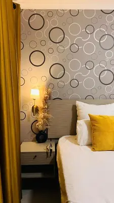 a bedroom with a bed with a patterned wall at UrbanCharm home away from home Affordable Luxury in Polokwane