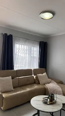 a living room with a couch and a table at UrbanCharm home away from home Affordable Luxury in Polokwane