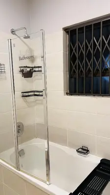 a shower with a glass door in a bathroom at UrbanCharm home away from home Affordable Luxury in Polokwane