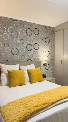 a bedroom with a large bed with yellow pillows at UrbanCharm home away from home Affordable Luxury in Polokwane