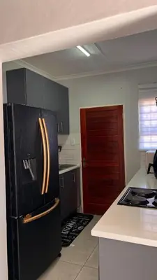 a kitchen with a black refrigerator and a counter at UrbanCharm home away from home Affordable Luxury in Polokwane