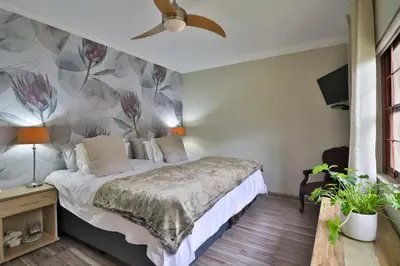 a bedroom with a bed with a flower wallpaper at Panorama View Pool House Steiltes in Nelspruit