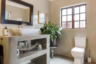 a bathroom with a sink and a toilet and a mirror at Panorama View Pool House Steiltes in Nelspruit