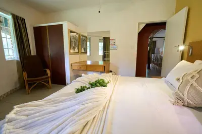 a bedroom with a white bed with flowers on it at Sable Ranch Selfsorg in Brits