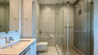 a bathroom with a shower and a toilet and a sink at Deluxe fully furnished apartment in Menlyn Maine residence 902 in Pretoria
