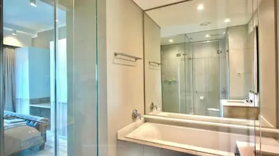 a bathroom with a tub and a glass shower at Deluxe fully furnished apartment in Menlyn Maine residence 902 in Pretoria