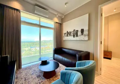 a living room with a couch and a large window at Deluxe fully furnished apartment in Menlyn Maine residence 902 in Pretoria