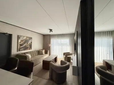 a living room with a couch and a table and chairs at Legacy Suites Montana in Pretoria