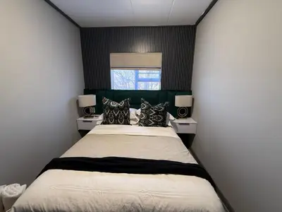a bedroom with a large bed and a window at Legacy Suites Montana in Pretoria