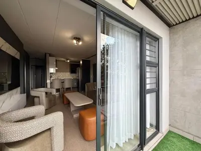 a living room with glass doors and chairs and a table at Legacy Suites Montana in Pretoria