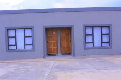 a white building with three windows on it at Exodus Guesthouse Mahlakwena Stee'lpoort in Steelpoort