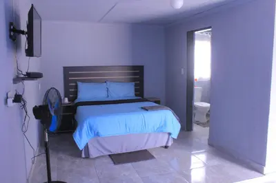 a bedroom with a bed in a blue room at Exodus Guesthouse Mahlakwena Stee'lpoort in Steelpoort