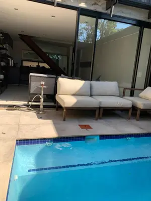 a living room with a couch and a swimming pool at 5 Bronco The Polofields in Midrand