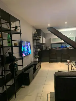 a living room with a flat screen tv on a shelf at 5 Bronco The Polofields in Midrand