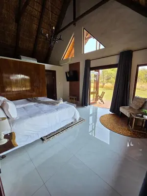 a bedroom with a large bed and a large window at 76 Zebula- Premium Luxurious Villa in Bela-Bela! in Warmbaths