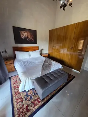 a bedroom with a bed with a large wooden headboard at 76 Zebula- Premium Luxurious Villa in Bela-Bela! in Warmbaths