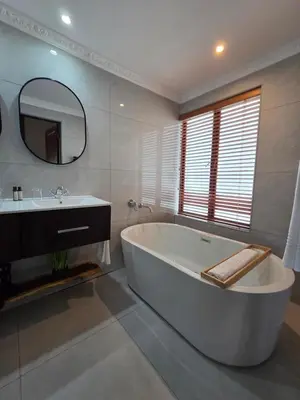 a large white bathroom with a tub and a sink at 76 Zebula- Premium Luxurious Villa in Bela-Bela! in Warmbaths
