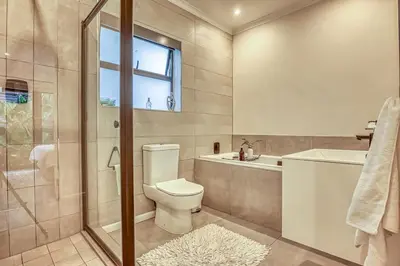 a bathroom with a toilet and a shower and a sink at Pecanwood Summit Shores Villa in Hartbeespoort