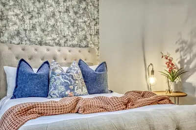 a bed with blue pillows and a blanket on it at Pecanwood Summit Shores Villa in Hartbeespoort