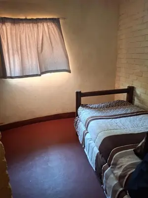 a bedroom with two beds and a window at Mpofu Farming and Guesthouses in Musina