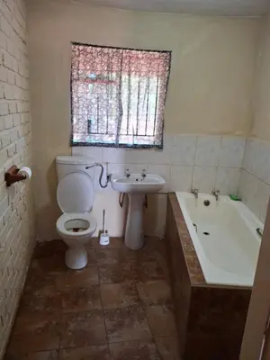 a bathroom with a toilet and a sink and a tub at Mpofu Farming and Guesthouses in Musina