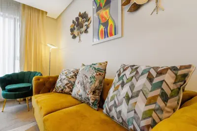 a living room with a yellow couch and a green chair at #Alimama Spaces The Manson's Steyn City in Midrand